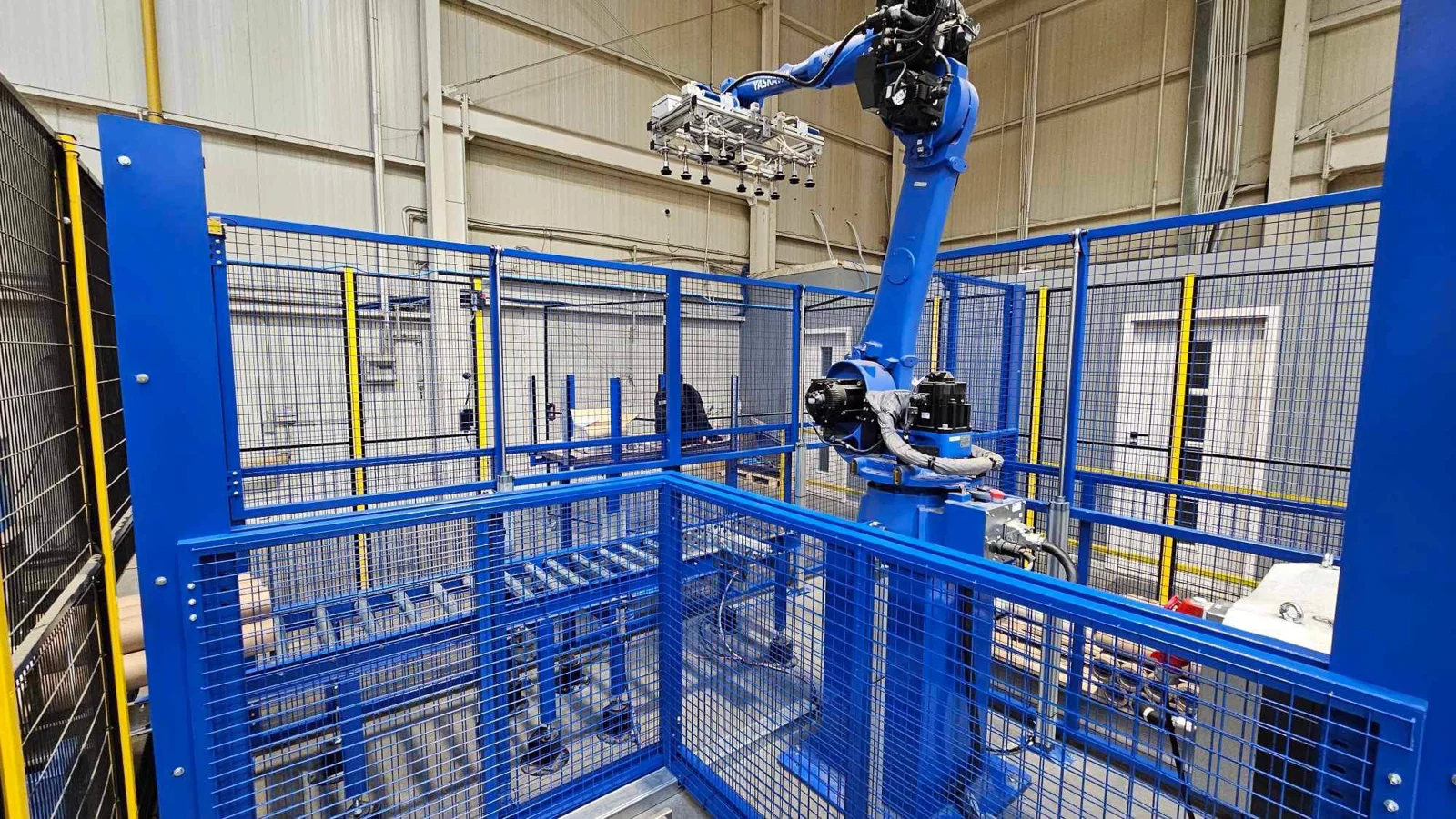 Robot Yaskawa z chwytakiem podciśnieniowym w wygrodzonym stanowisku produkcyjnym